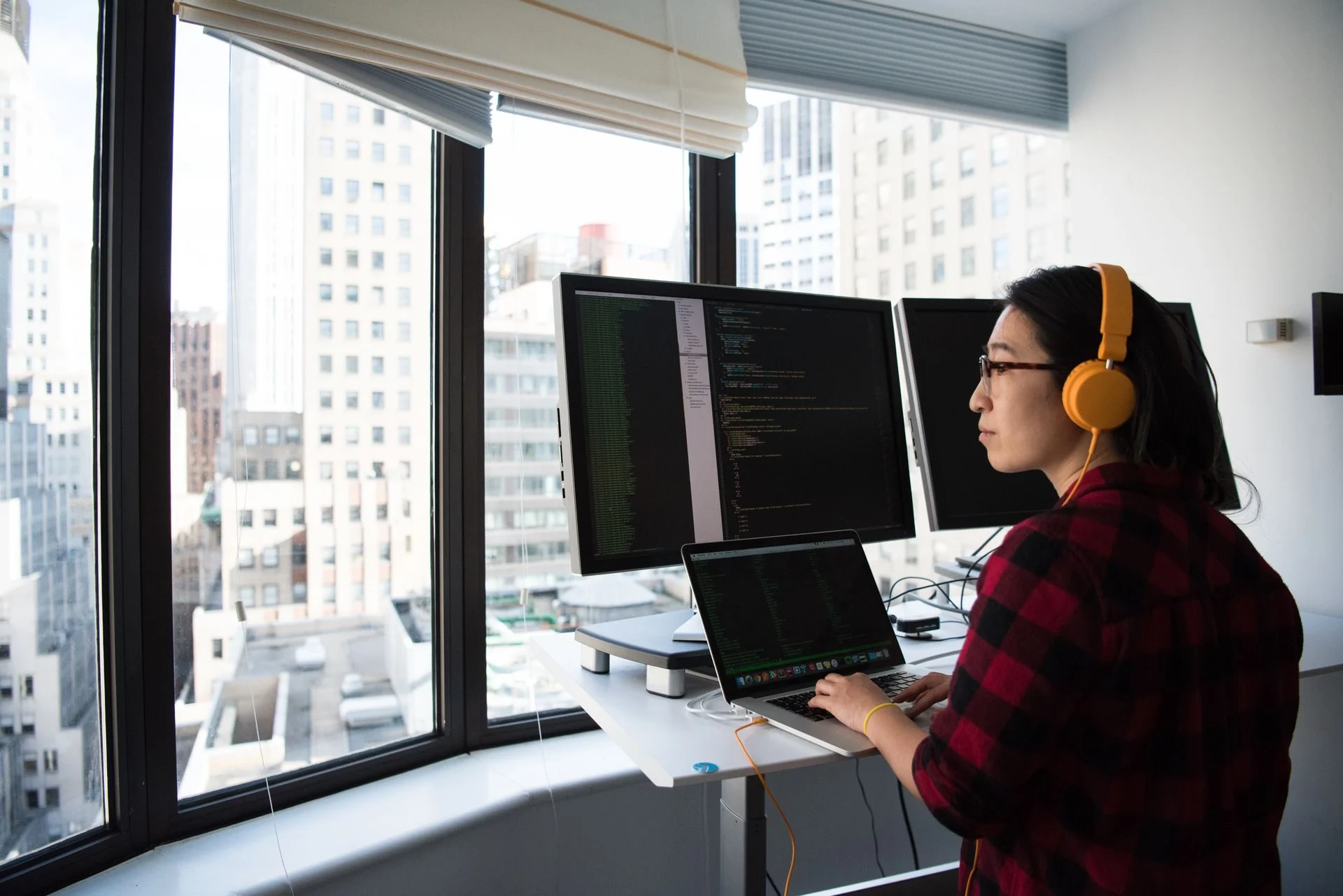 A developer writing code at a standing desk